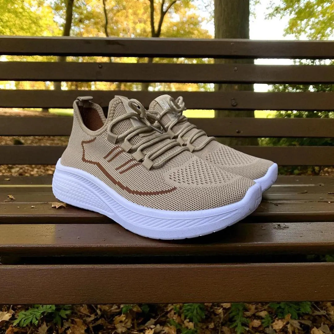 Beige sneaker with white sole on a wooden bench outdoors