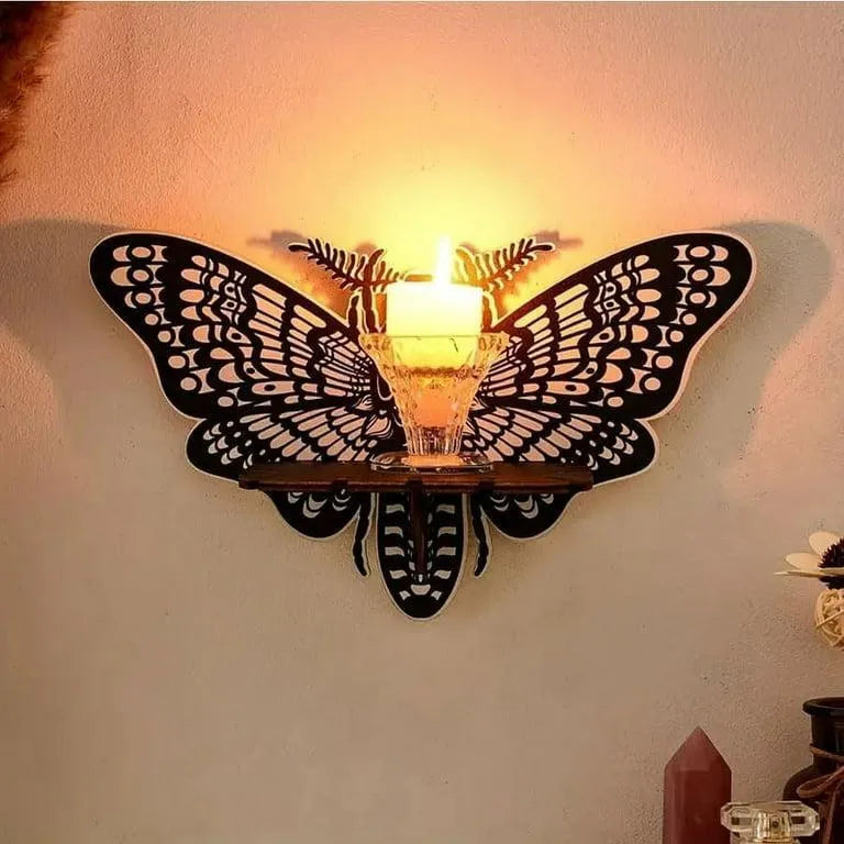 Butterfly-shaped wall light fixture with candle on a beige wall.