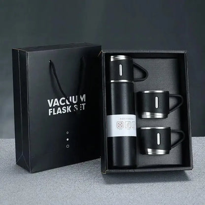 Vacuum flask set with two mugs in a black gift box on a gray background