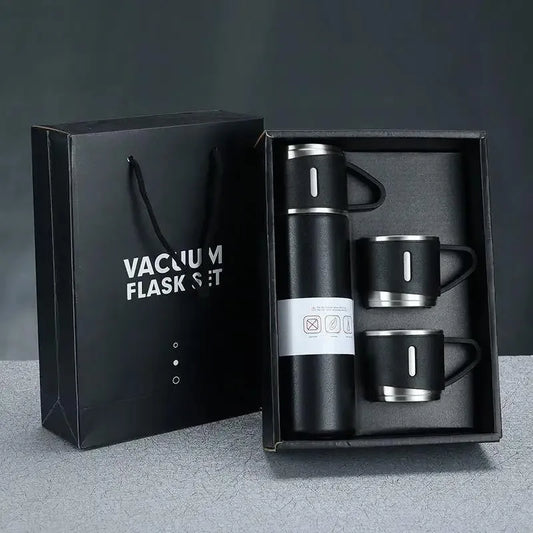 Vacuum flask set with two mugs in a black gift box on a gray background
