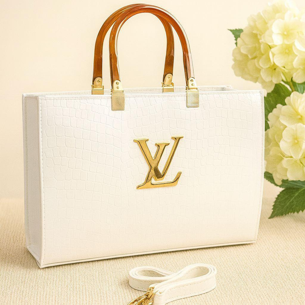 White handbag with gold accents and a matching strap on a beige background